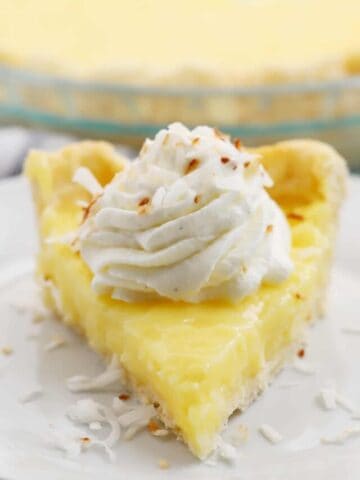 a slice of coconut cream pie on a white plate