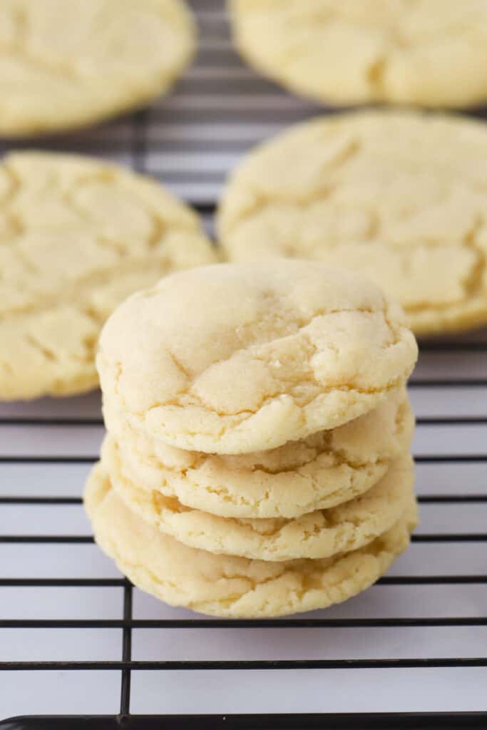 A stack of chewy sugar cookies on a wire cooling rack after baking, sugar cookie recipe chewy.
