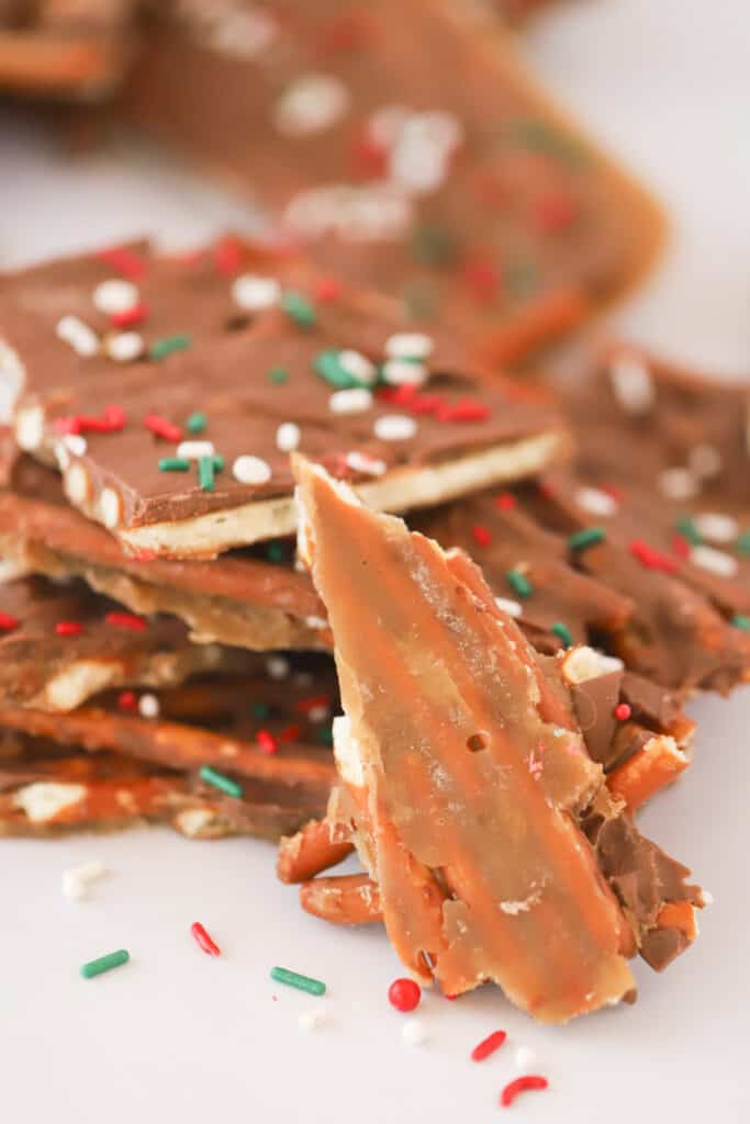 Broken pieces of toffee covered with chocolate and holiday sprinkles.