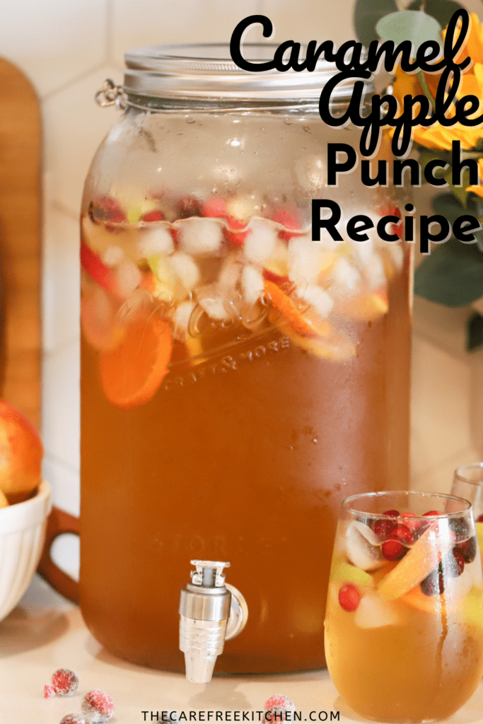 Pinterest pin for Caramel Apple Punch that shows a large pitcher of punch with ice cubes, sliced apples, oranges and cranberries.