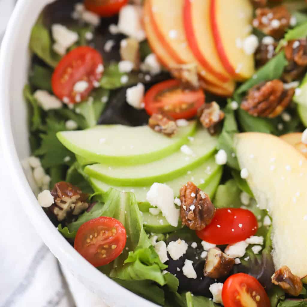 leafy green salad with a white bowl, green salad with apple. fancy salad for easter. 