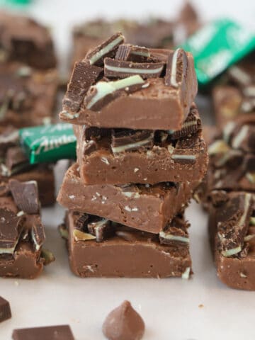reese peaniut butter fudge stacked in a pile with mints around
