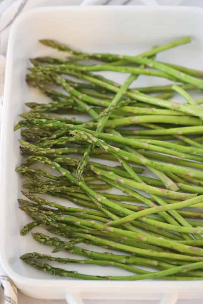 Asparagus spears in a baking dish ready to roast.