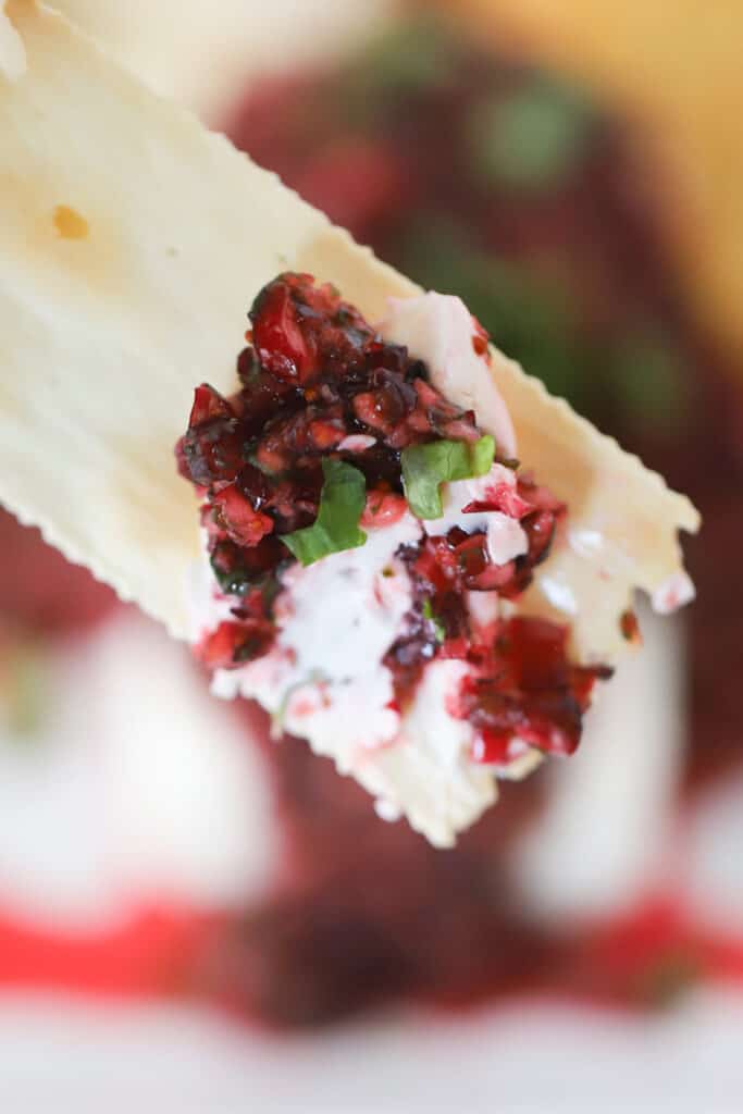 A cracker with Cranberry Salsa and cream cheese on a cracker.