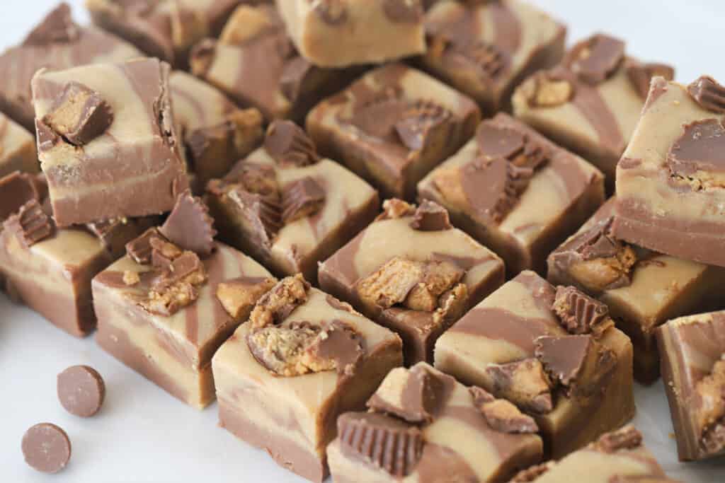 Reese's peanut butter fudge on a cutting surface, cut into bite sized pieces.