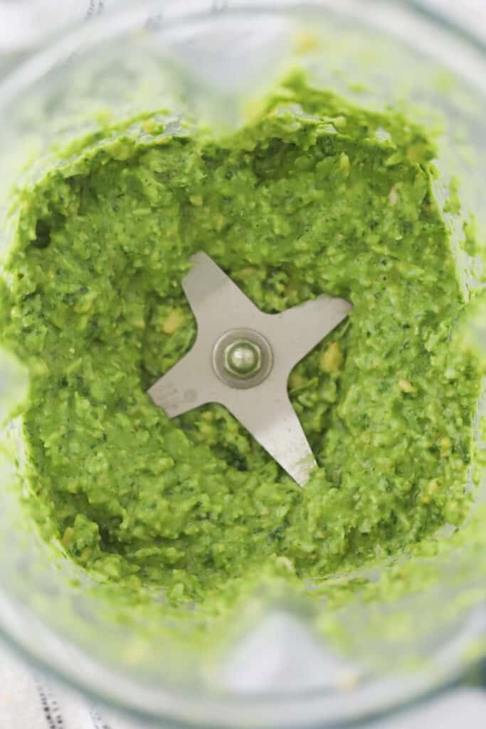 Bright green fresh pesto sauce in a blender. 