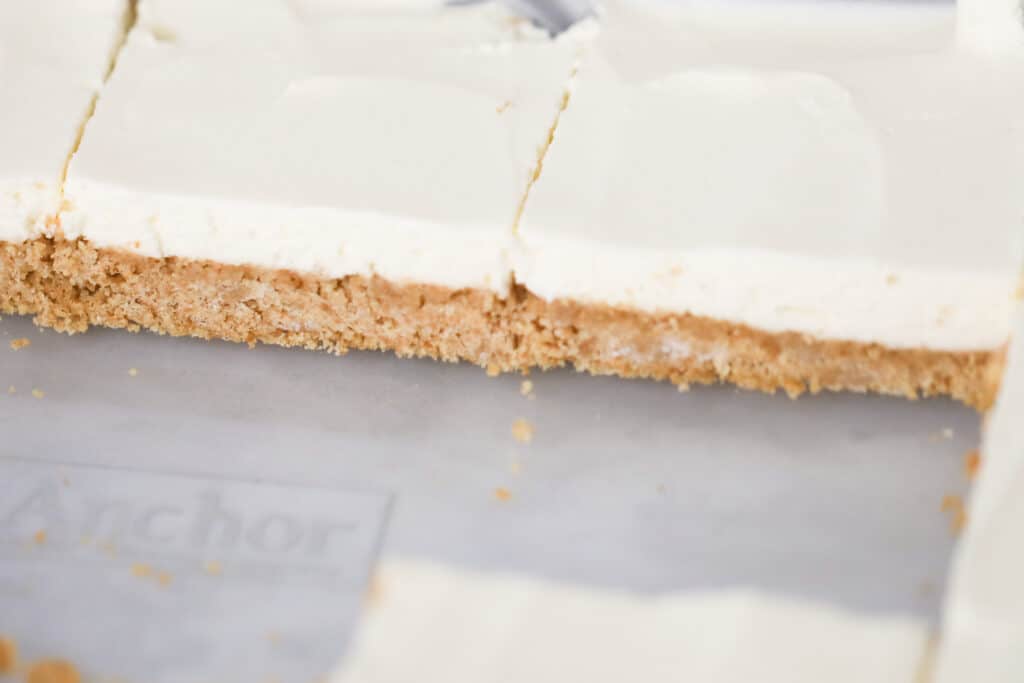 No-Bake Cheesecake Bars cut into pieces on a sheet tray.