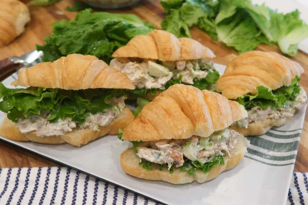 chicken salad for sandwiches on croissants displayed on a serving plate.
