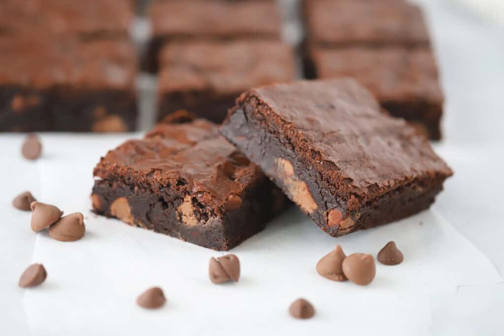 Chewy Fudge Brownies on a tabletop with chocolate chips.