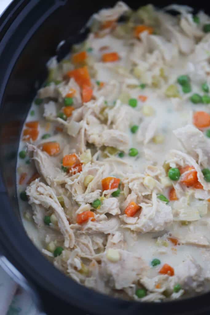 Crockpot Chicken Pot Pie filling with carrots and peas.