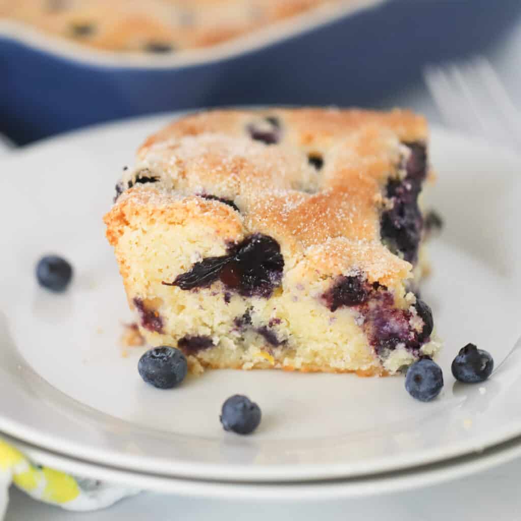 lemon blueberry breakfast cake on a serving plate, the best buttermilk blueberry breakfast cake.