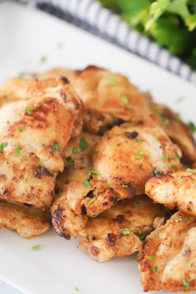 An example of a healthy dinner idea - baked chicken on a white serving platter garnished with fresh herbs.