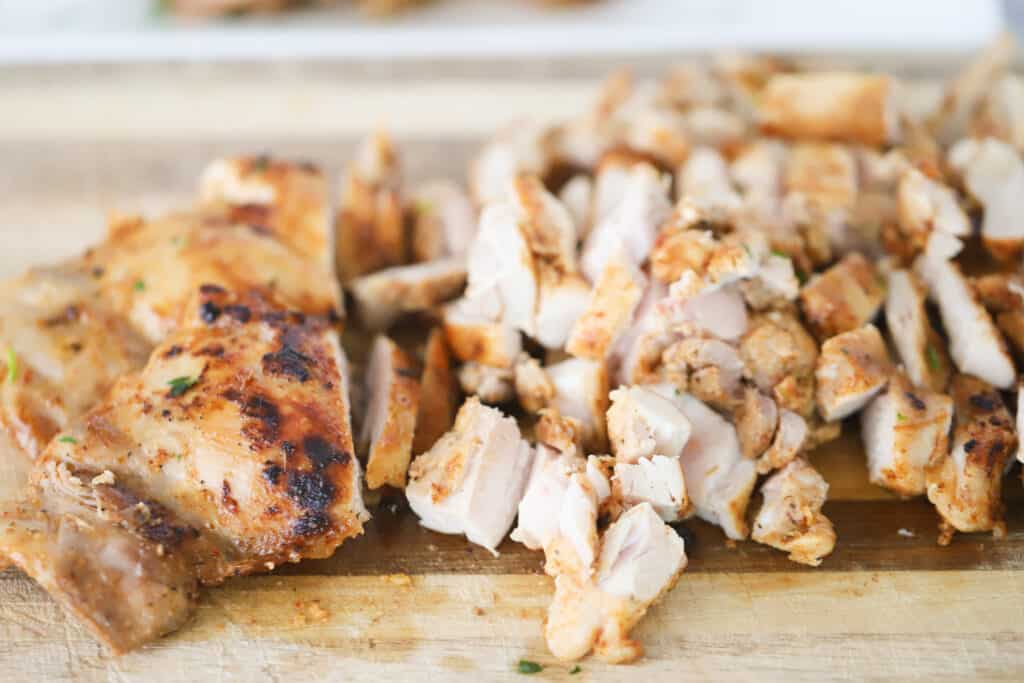 A cutting board with chopped sauteed chicken for easy chicken quesadillas. Marinade for chicken quesadillas.