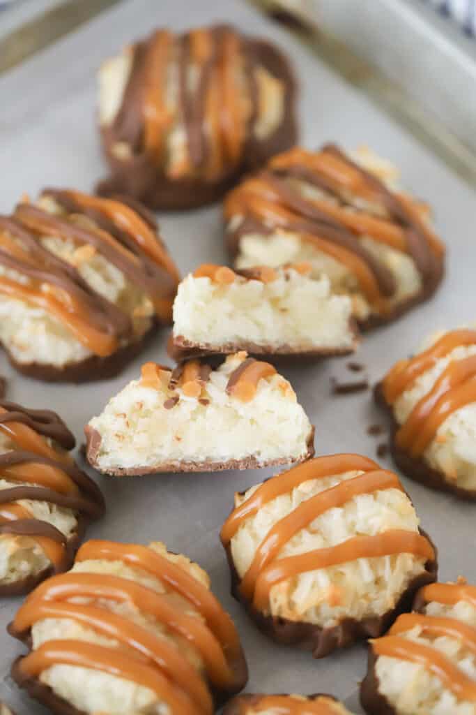 Coconut macaroons on a baking sheet drizzled with chocolate and caramel.
