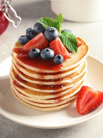 Pancakes with strawberry syrups on a stack of pancakes, best brunch recipes