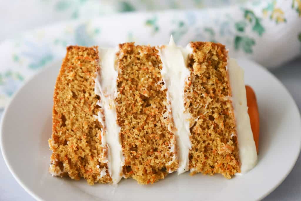 A slice of our classic Carrot Cake recipe on a white plate.