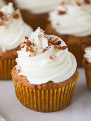 carrot cake cupcakes with walnuts on top
