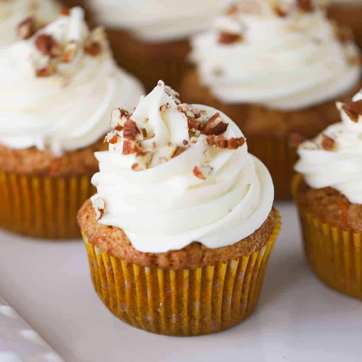 carrot cake cupcakes with walnuts on top