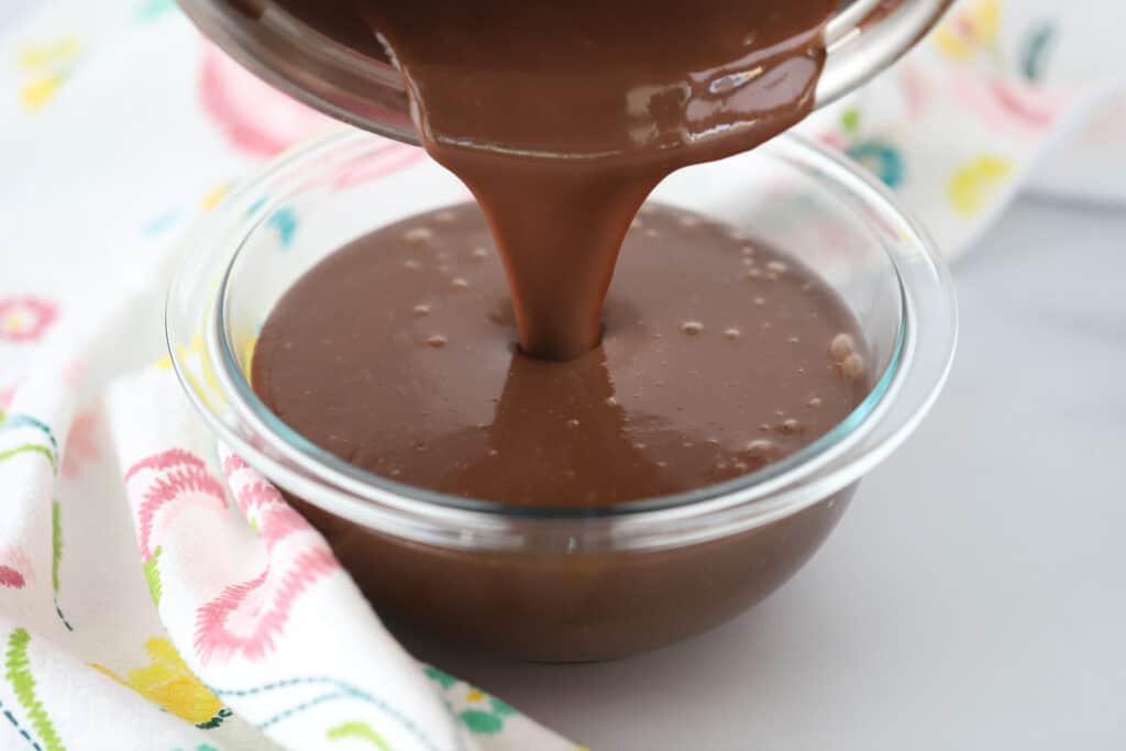 Homemade Chocolate Pudding being poured into a glass bowl.