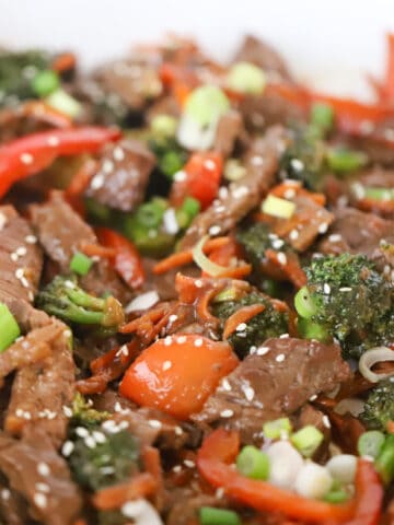 Korean beef Stir fry recipe garnished with sesame seeds and green onions.