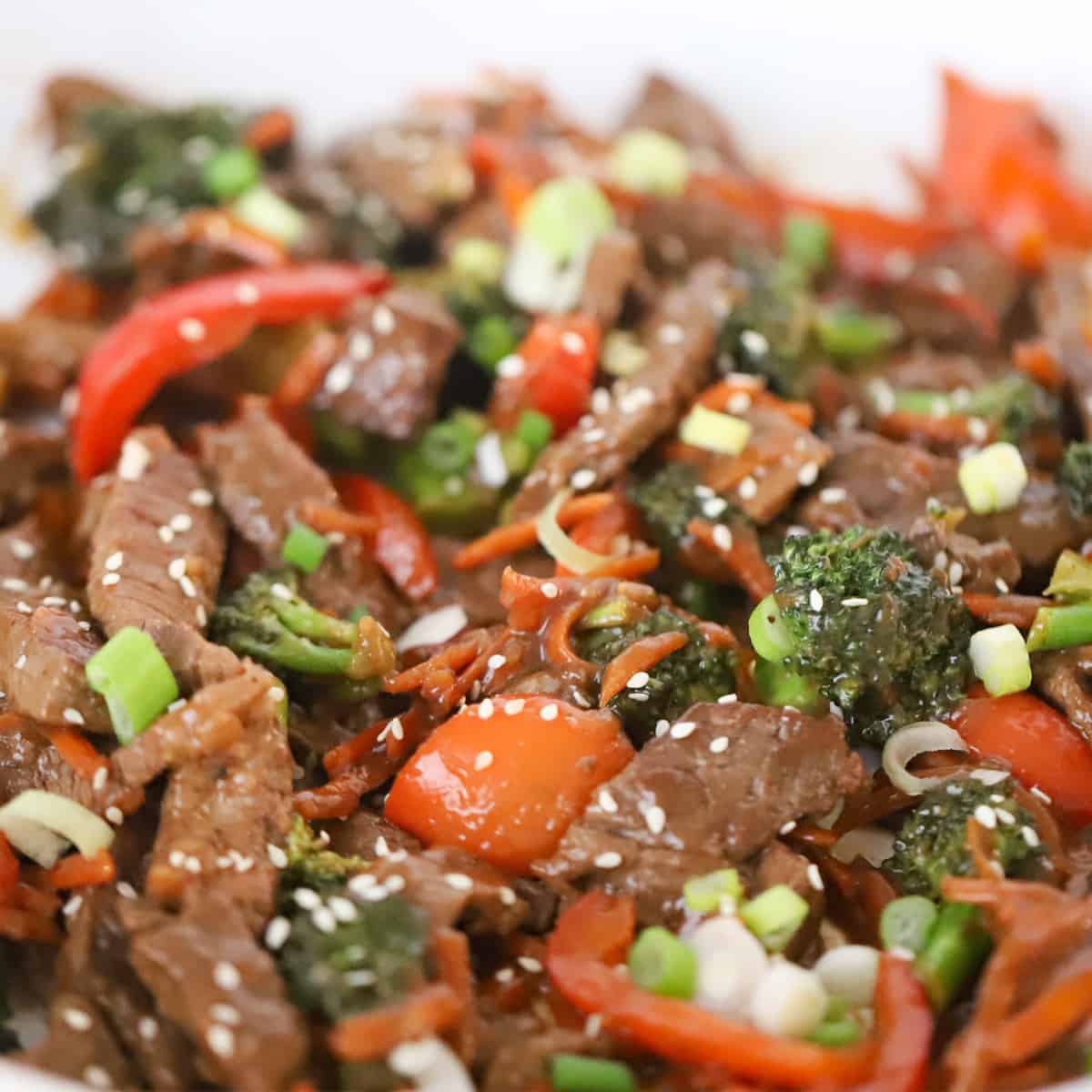 Korean beef Stir fry recipe garnished with sesame seeds and green onions.