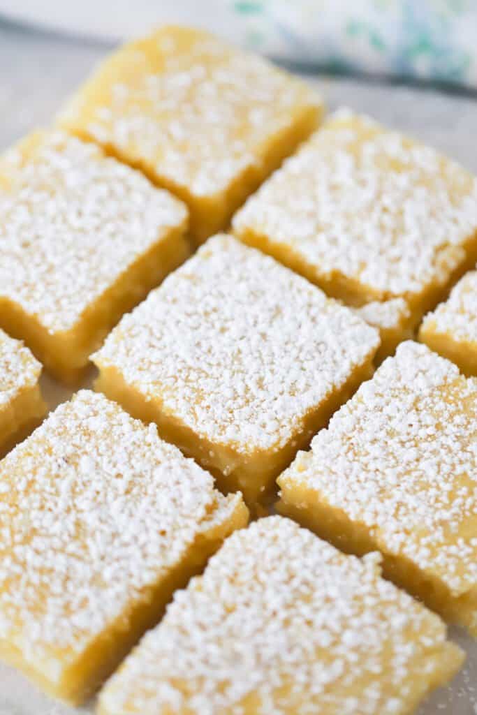 A tray of cut easy lemon bars recipe from scratch dusted with powdered sugar, easy lemon bars recipe.