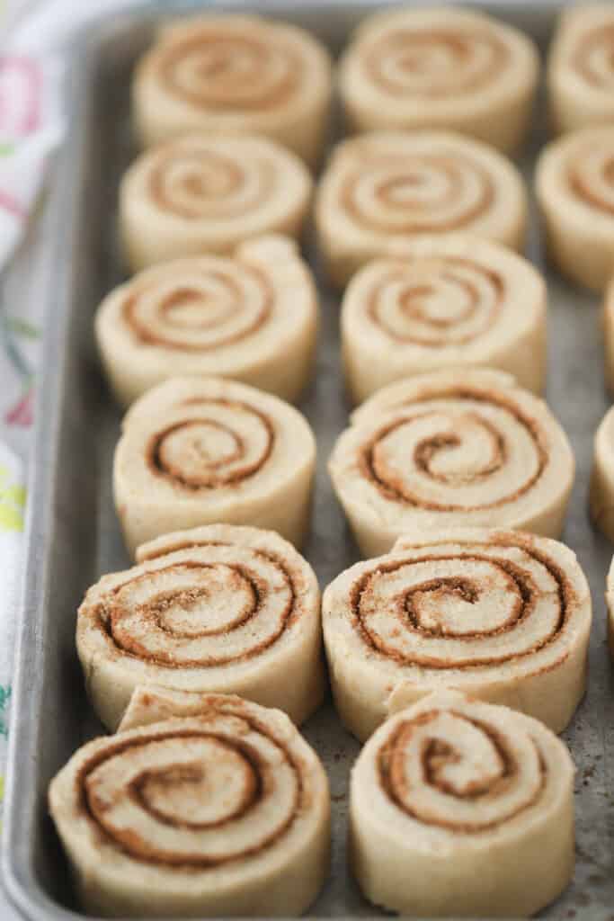 Whole Wheat Cinnamon Rolls lined up in a baking sheet before baking.
