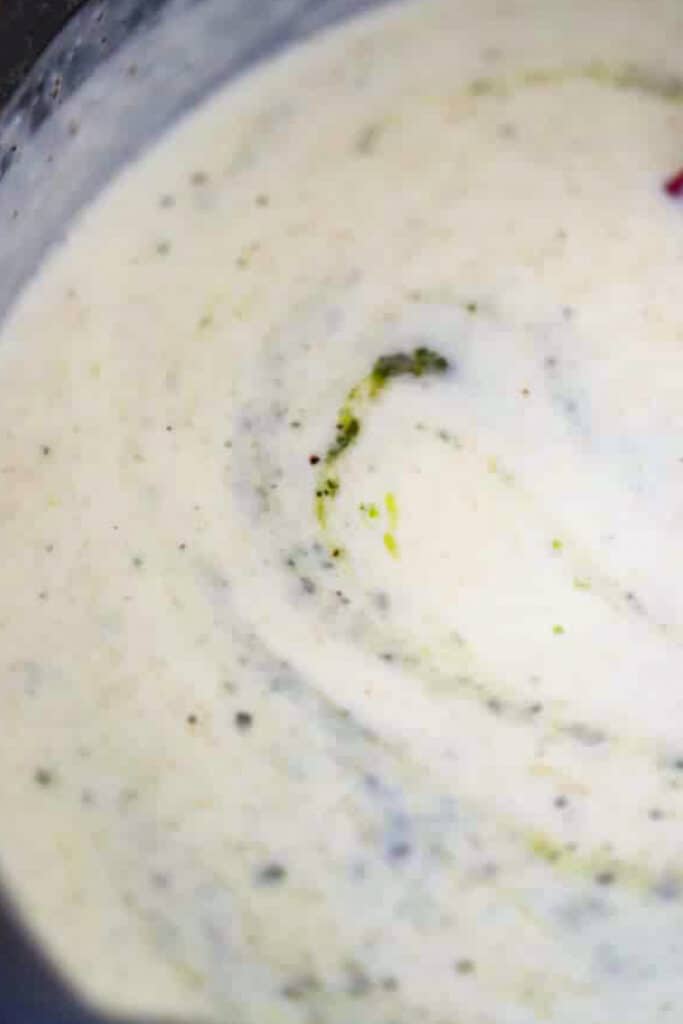 Creamy alfredo and pesto sauce in a small bowl.