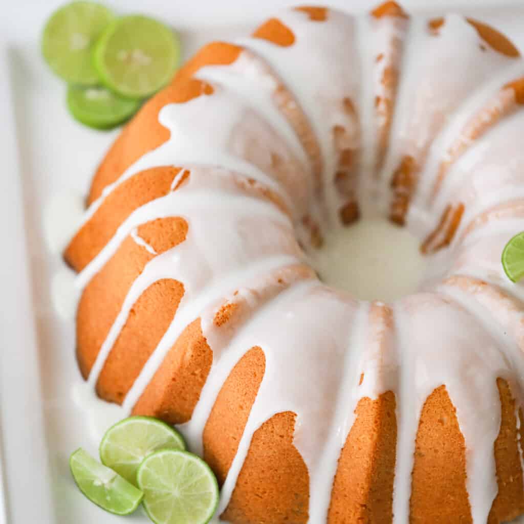 key lime pound cake recipe with limes on a serving platter