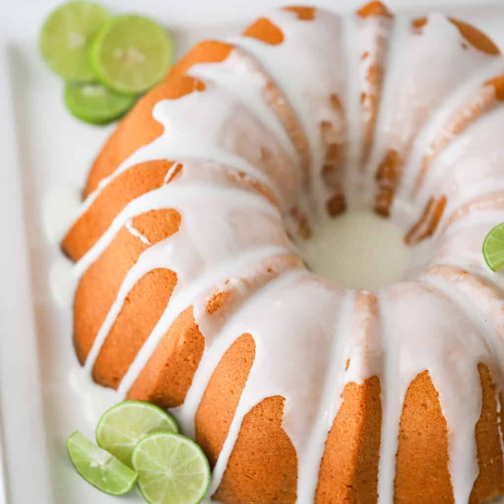 recipe key lime pound cake recipe with limes on a serving platter. key lime cake recipe.