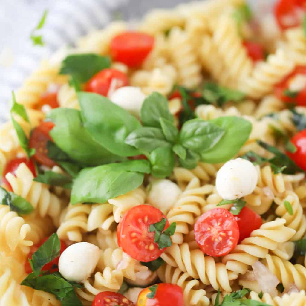 Caprese pasta salad with tomatoes and basil.