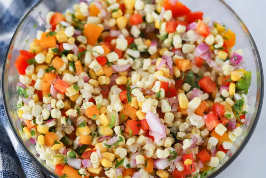 A large glass mixing bowl full of Corn Salsa.