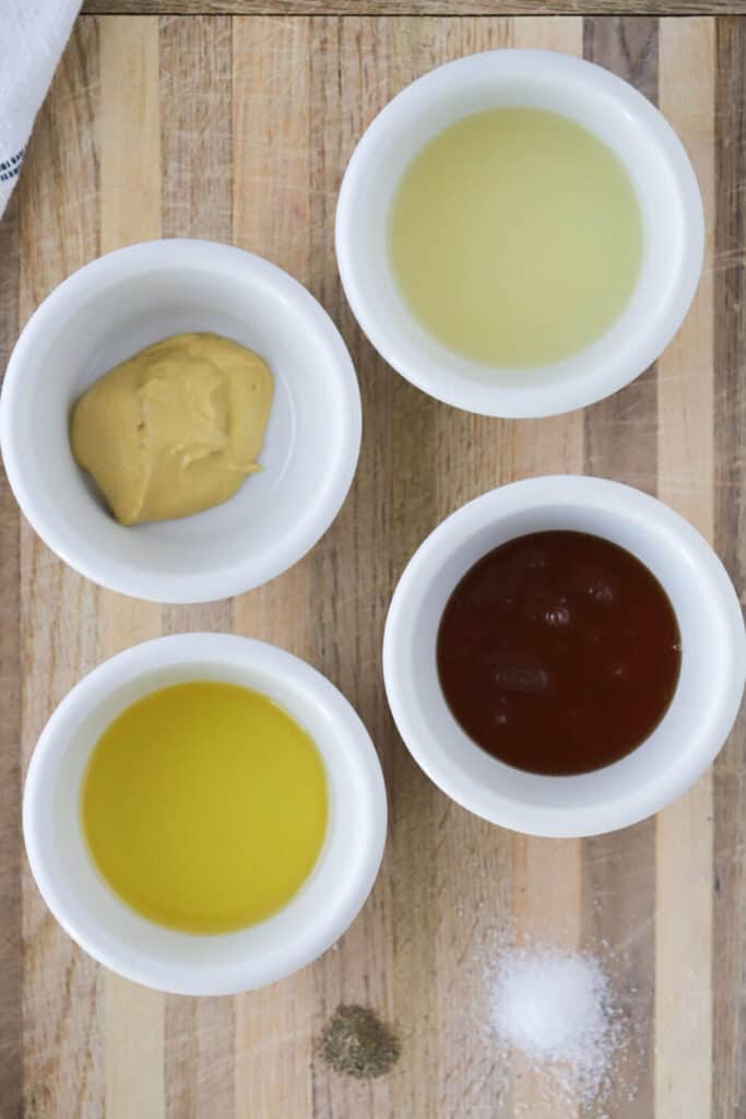 Ingredients  and how to make homemade Honey Mustard Dressing in separate ramekins on a cutting board. honey mustard dressing for salad.