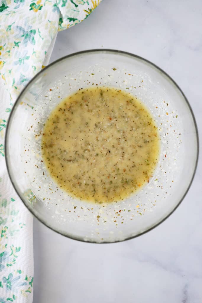 Making Italian Dressing in a large glass bowl.