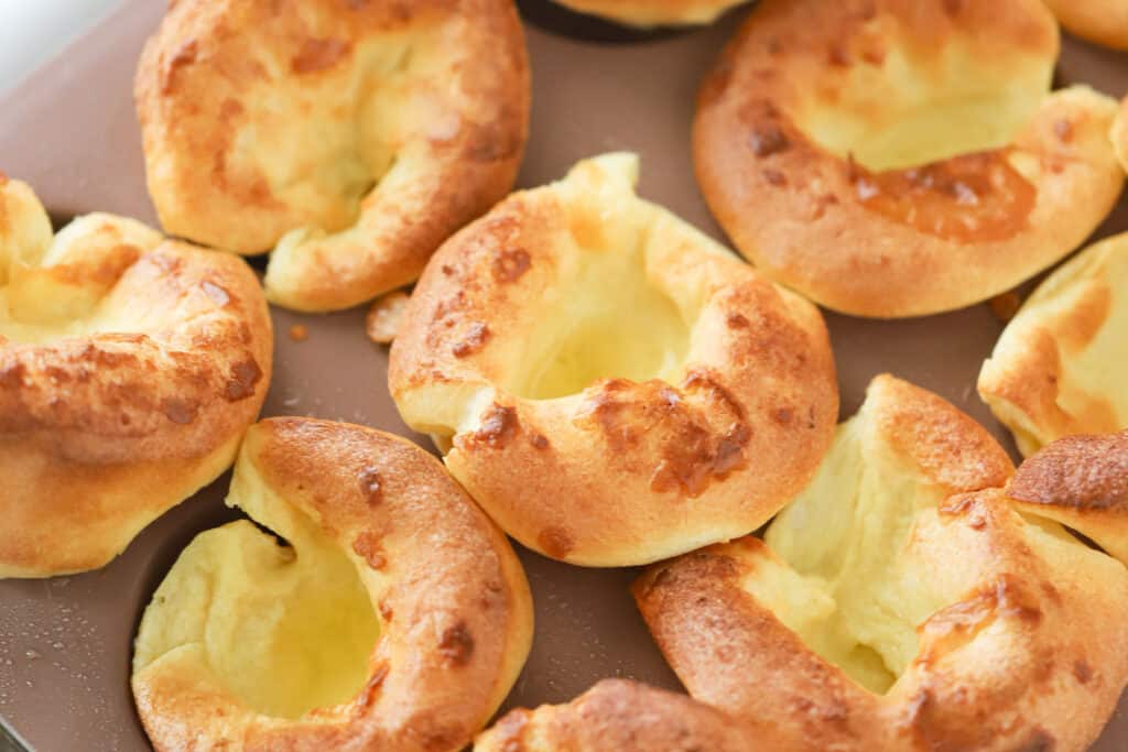 Freshly baked Popovers in a muffin pan.