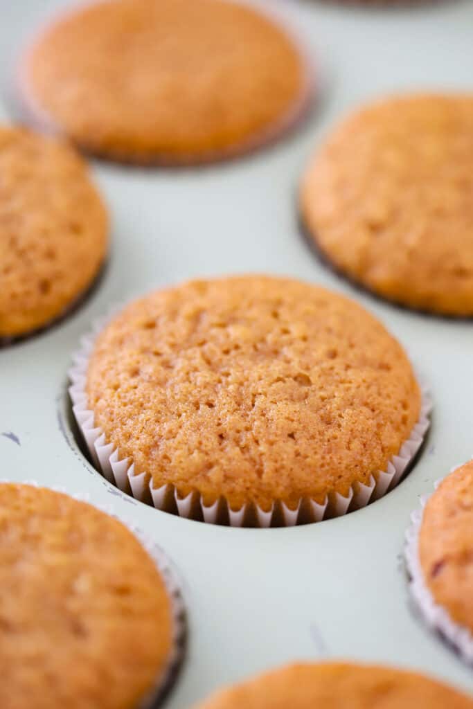 A close up of baked Pumpkin Muffins in a muffin tin.