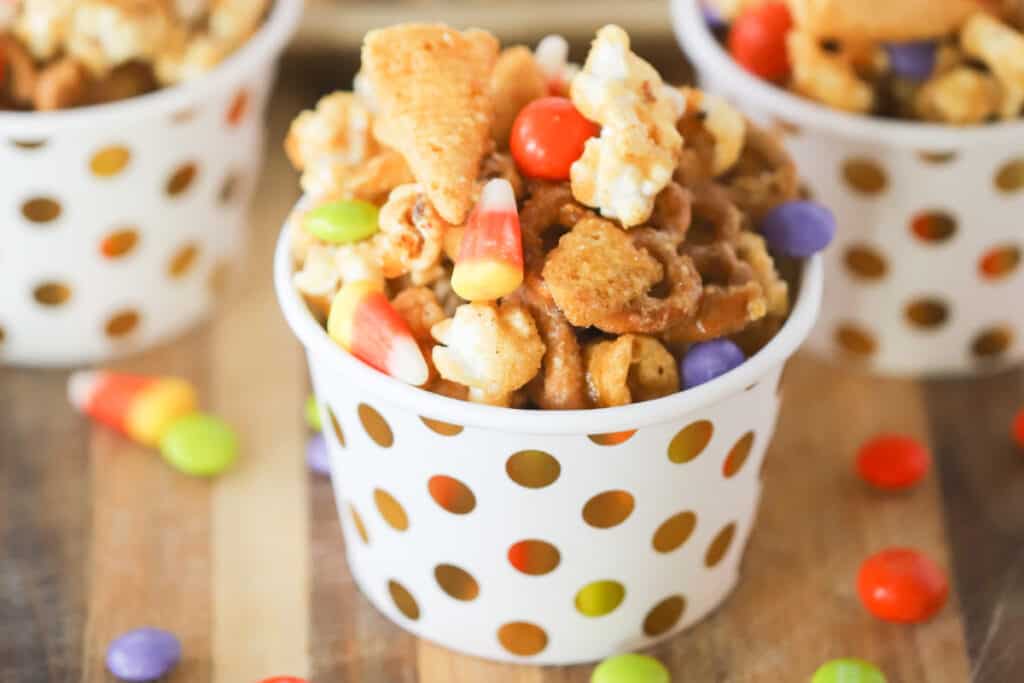 Small individual decorative cups full of Sweet Fall snack mix. fall mix, fall party snack mix recipe. 