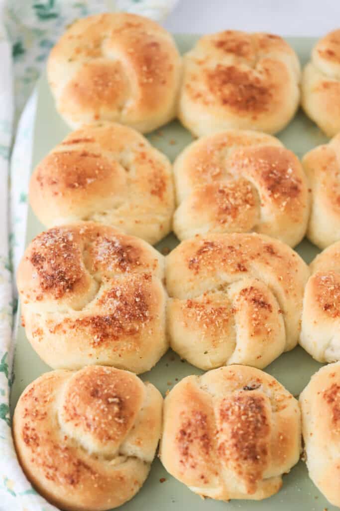 A muffin tin of freshly baked homemade Garlic Knots. easy garlic knots recipe, bread knots.