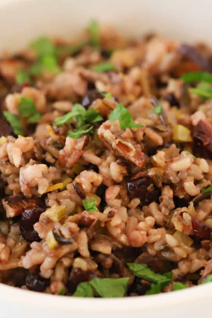 A close up of a bowl of Thanksgiving Wild Rice, topped with fresh parsley.