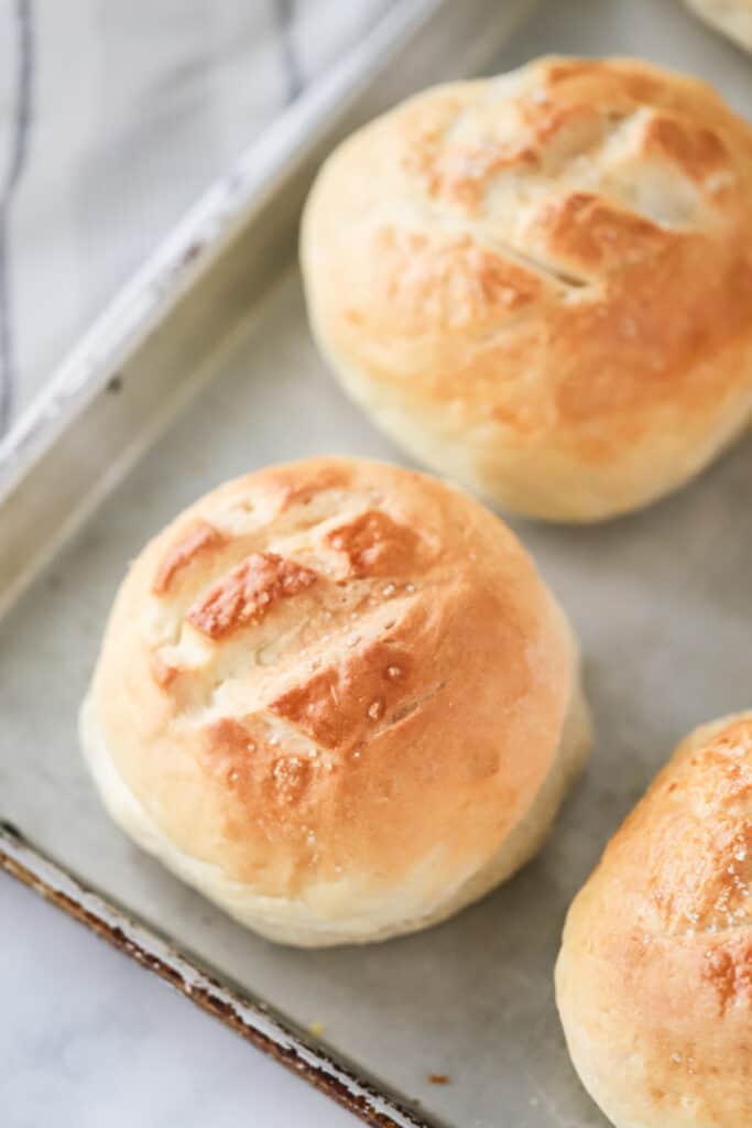 Baked loaves of bread on a sheet tray. recipe for bread bowls, bread bowl soup recipe. 