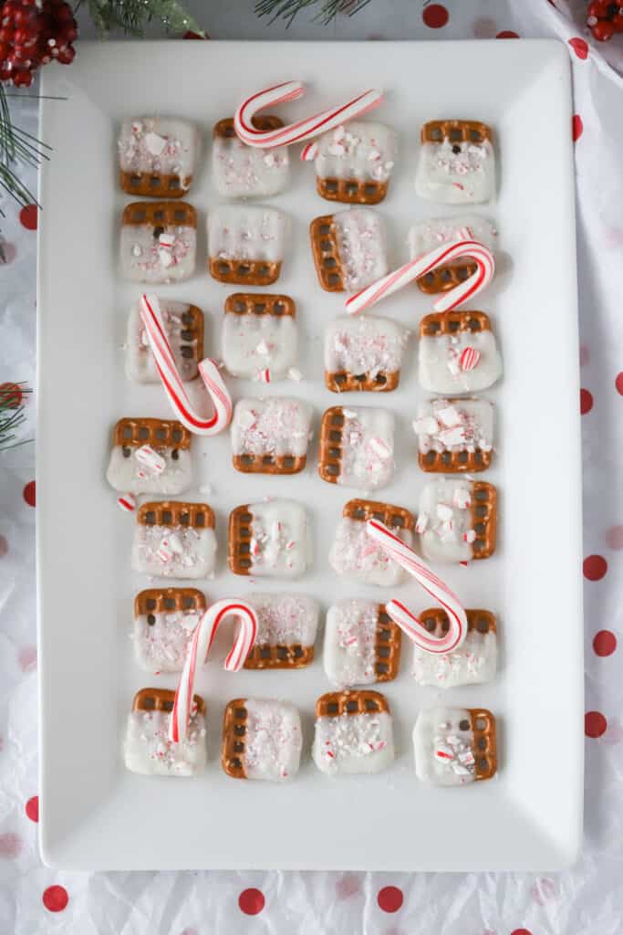 A white serving tray full of chocolate covered Peppermint Pretzels