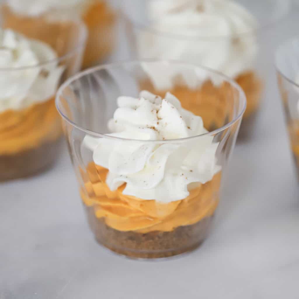 Mini pumpkin cheesecakes in small plastic cups–one of the many best pumpkin dessert recipes on this list.