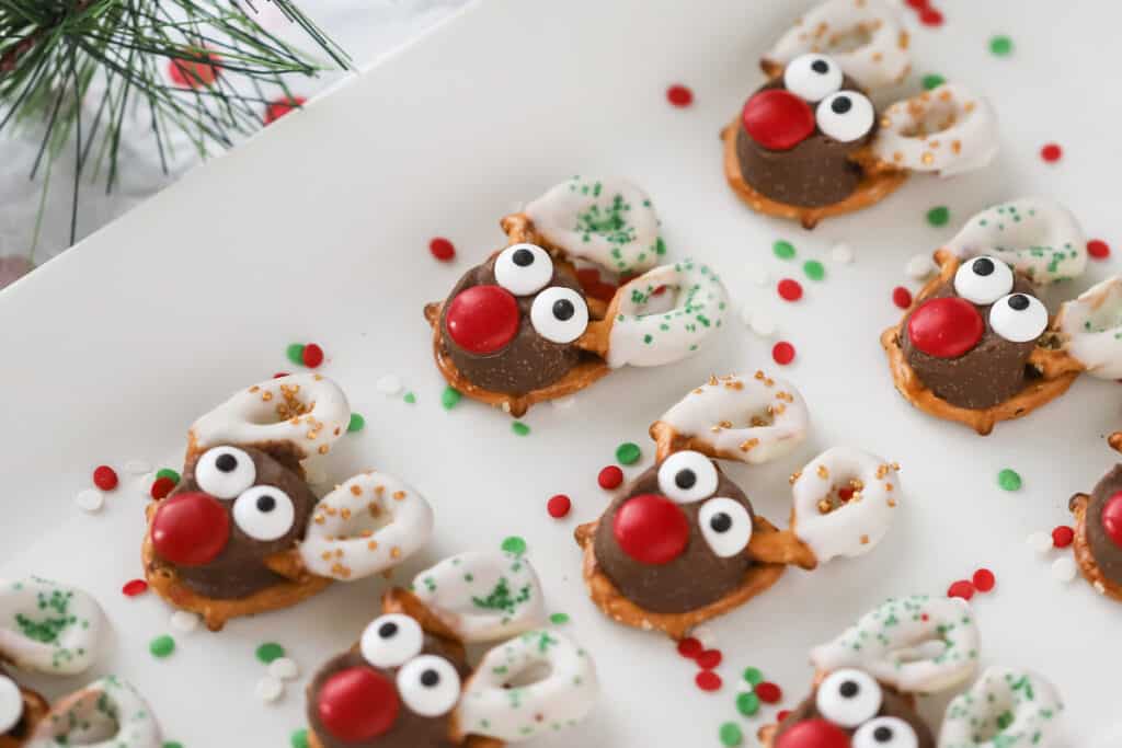 A white serving platter with decorated Reindeer Pretzels lined up.