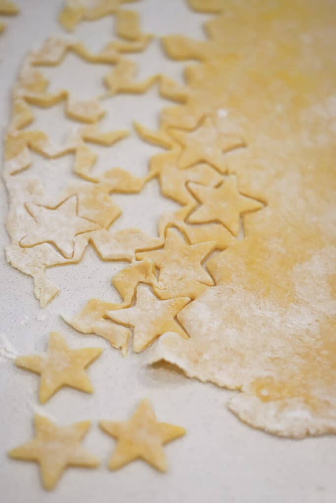 A countertop with rolled pasta dough cut into star shapes. how to cook egg noodles, eggs noodles easy. Hlow long cook egg noodles.