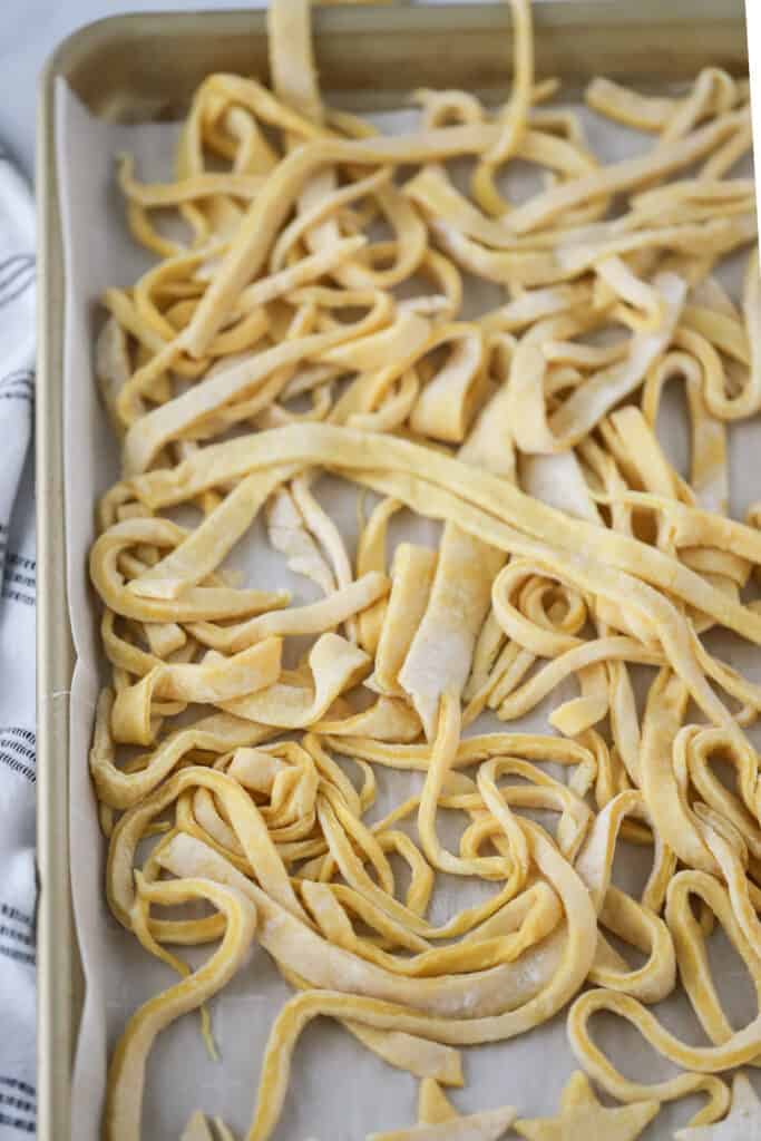 A sheet tray full of fresh noodles. how to prepare egg noodles, egg noodle dishes.