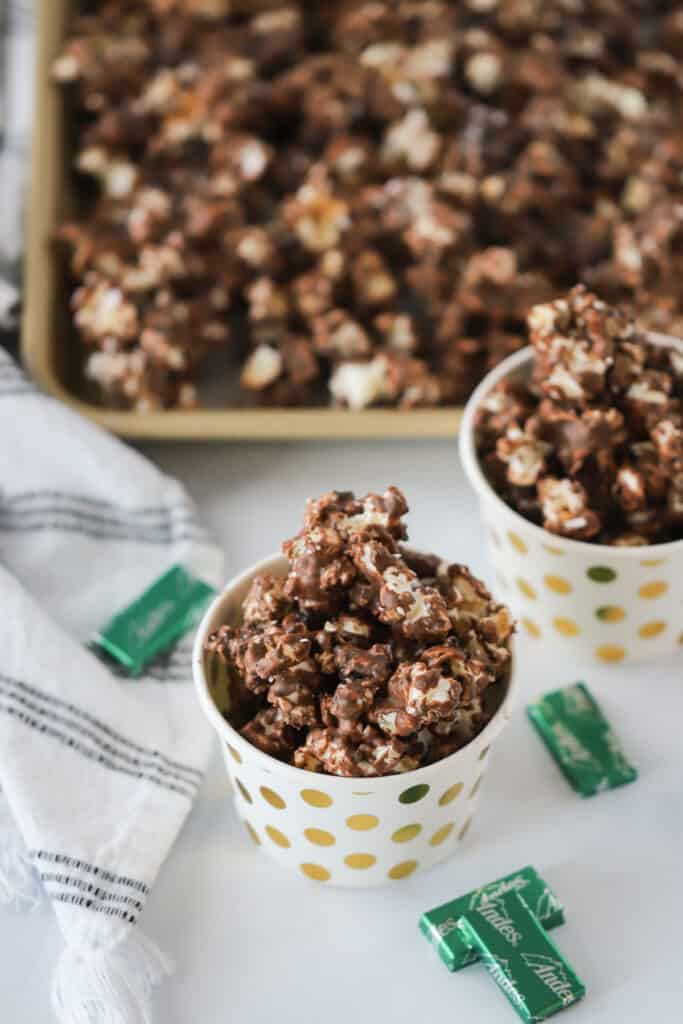Small decorative cups full of Andes Chocolate Mint Popcorn, an easy recipe for peppermint popcorn.