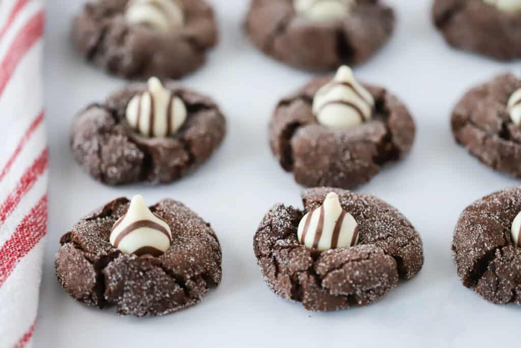 A platter full of Chocolate Kisses Cookies topped with striped Hershey's Kisses.