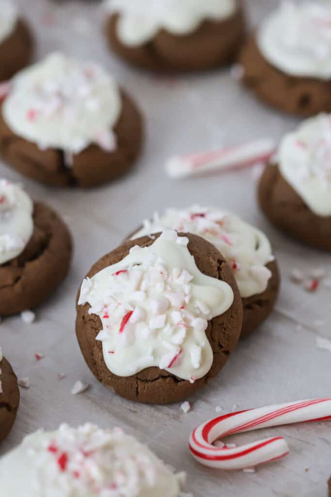 Chocolate Peppermint Meltaway Cookies on a baking sheet topped with melted chocolate and crushed candy canes.
