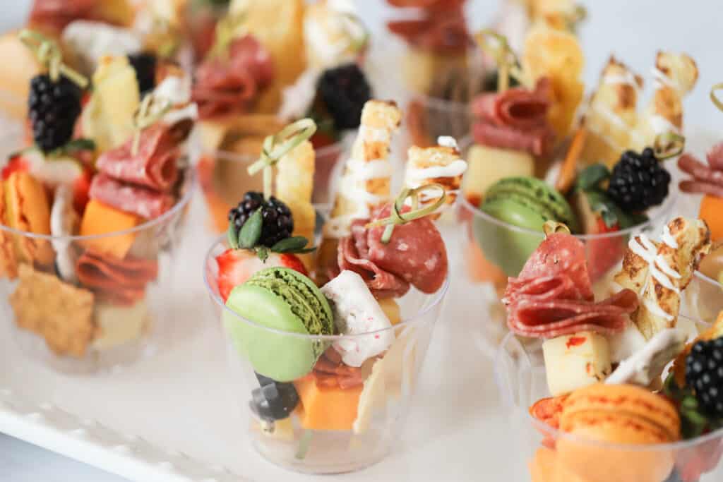 Individual Charcuterie cups on a serving platter. individual appetizers in cups, mini appetizers in cups.