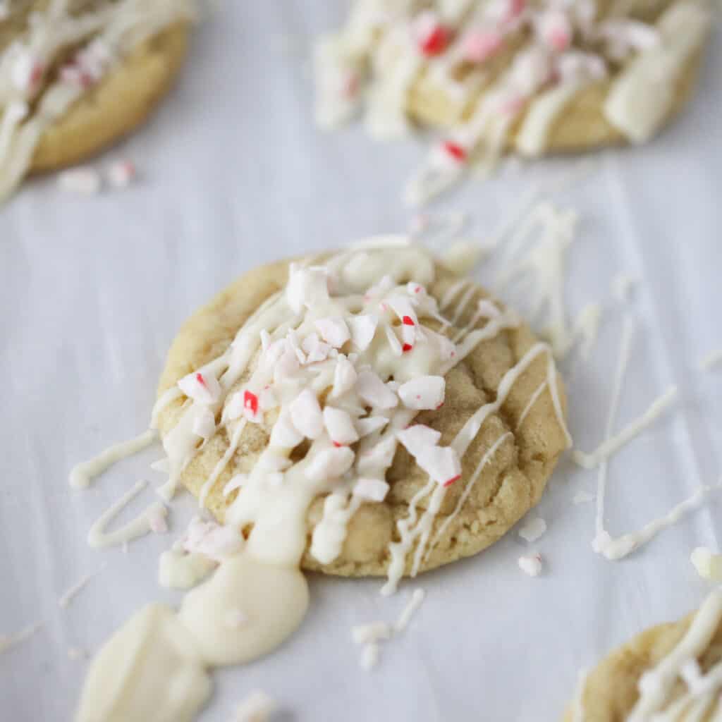 Peppermint Meltaway Cookies drizzled with white chocolate and topped with crushed candy canes.